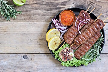  Kebab of minced beef or lamb with vegetables and herbs. Traditional meat kebab on rustic dinner...