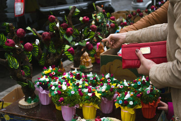 Commercial concept. Do shopping at market. Female hand hold wallet. Traditional Easter market in Yerevan. Easter decoration. Retail trade