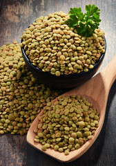 Composition with bowl of lentils on wooden table