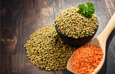 Composition with bowl of lentils on wooden table