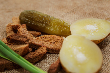 Boiled potatoes in a peel with salt and a green onion on a close-up table. Healthy food.