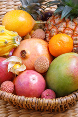 Lychee, pomegranate, mango. Exotic fruits in a basket.