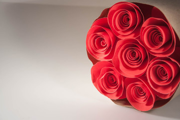 The flowers made of red paper. a red rose and a bouquet of flowers on a white background. copy space. background.