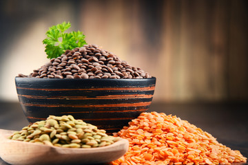 Composition with bowl of lentils on wooden table
