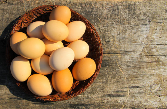 Eggs in wicker basket on wooden table