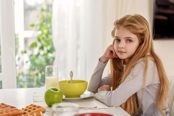 Obraz na płótnie Canvas Cute kid eating breakfast at home