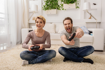Excited married couple playing console at home © Yakobchuk Olena
