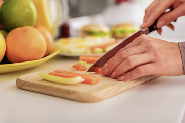 Housewife cutting vegetables by knife