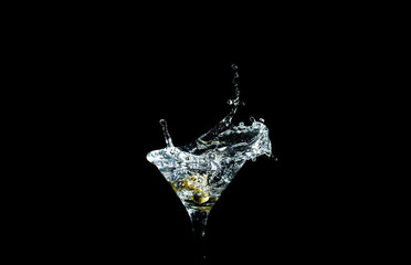 Olive splashing on cocktail isolated on black background
