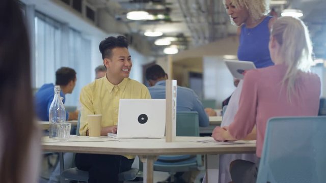  Business team working with technology & discussing ideas in modern office