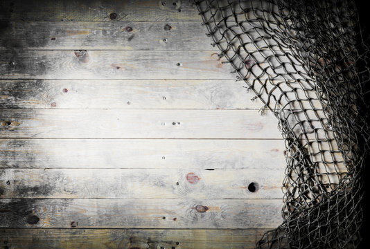Fishing nets over wooden background with copy space.