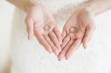 close up bride holds beautiful wedding ring on hand.