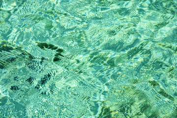 Crystal clear turquoise sea water surface with ripples. Abstract of sea surface under bright sunlight for background.