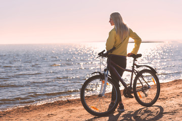 Fototapeta na wymiar A girl on a bicycle by the sea