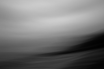 Abstract black and White image of waves crashing in over shore