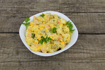 Russian traditional salad olivier on wooden table