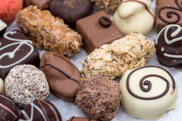 Top view on different of delicious chocolate candies, white, dark, and milk chocolate.