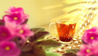 Cup of black tea on a wooden background. Morning, sunny and warm weather