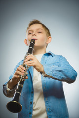 Fototapeta premium Handsome Caucasian boy play a Bassoon on grey background