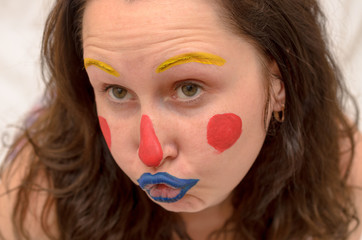 April Fools' joke girl with a clown face grimaces.
