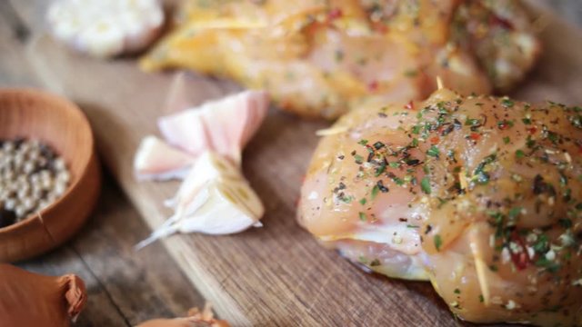 Spicy chicken breast with parsley and garlic on wooden board