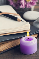 Open blank notebook, lit candle, flower