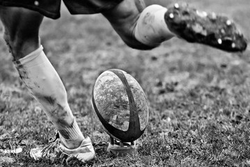 Legs of rugby player kicking ball - obrazy, fototapety, plakaty