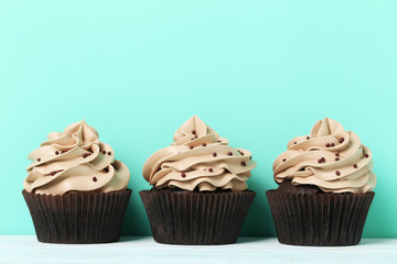 Tasty cupcakes on a green background