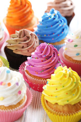 Tasty cupcakes on a white wooden table