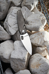 Pocket knife on stone background close up