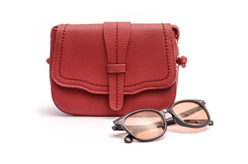 Red leather clutch and sunglasses still life