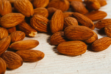 handful of almonds on a white wooden background