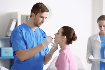 Fototapeta premium Plastic surgeon applying marks onto young woman's face prior to operation