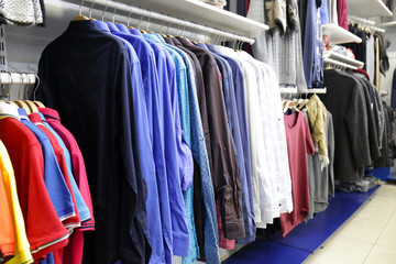 Rack with different clothes in modern shop