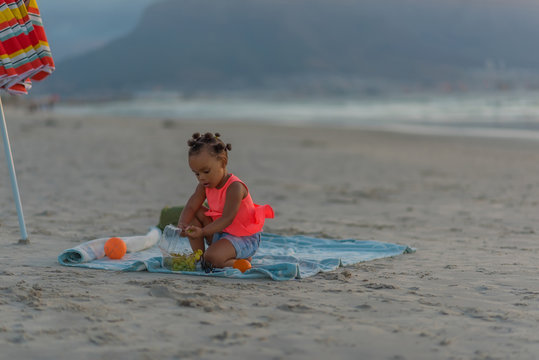 Little girl having snacks at the beach