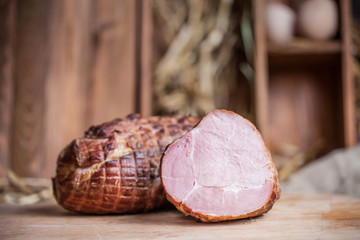Cut piece of meat on wooden desk. Box with eggs in the background.