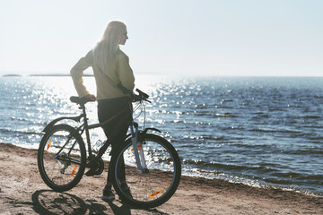 A girl on a bicycle by the sea