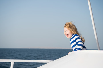 small happy baby boy captain of yacht in marine shirt