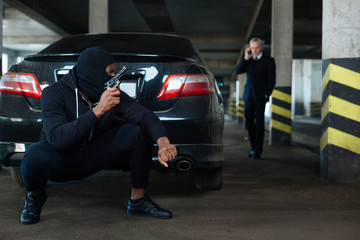 Fototapeta premium Dangerous well built criminal sitting in ambush