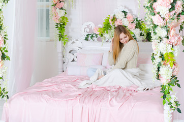 Beautiful young woman resting on a bed decorated with flowers