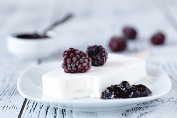 Homemade blackberry ice cream or popsicles decorated green mint leaves on teal rustic table, frozen fruit juice