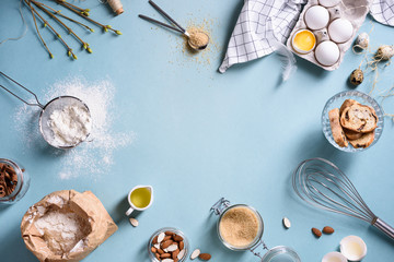 Fototapeta na wymiar Baking or cooking background frame. Ingredients, kitchen items for baking cakes. Kitchen utensils, flour, eggs, almond, cinnamon, oil. Text space, top view.