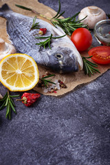 Uncooked dorado fish with rosemary and vegetables
