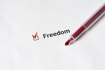 Freedom of speech. Red pen and the inscription freedom with check mark on the white paper