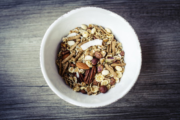 bowl with muesli on the wooden table prepared for healthy breakfast
