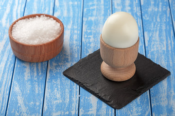 boiled egg and salt on a wooden background
