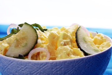 A delicious homemade creamy potato salad on a picnic table.