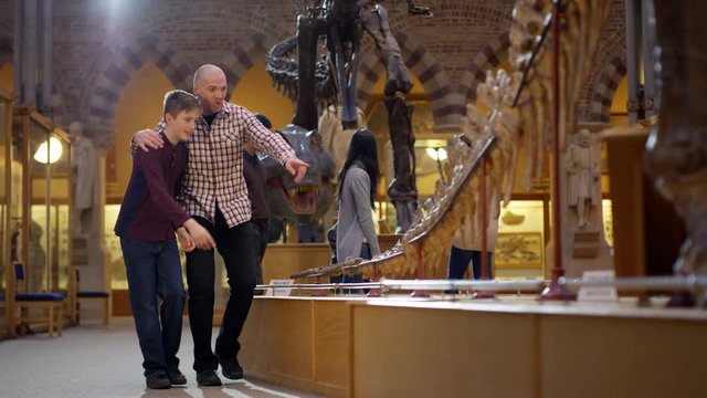  Father & son in natural history museum looking at the exhibits with amazement