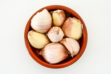 Closeup of a bowl of pink garlic cloves