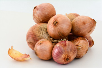 Closeup of a bundle of brown onions on white background